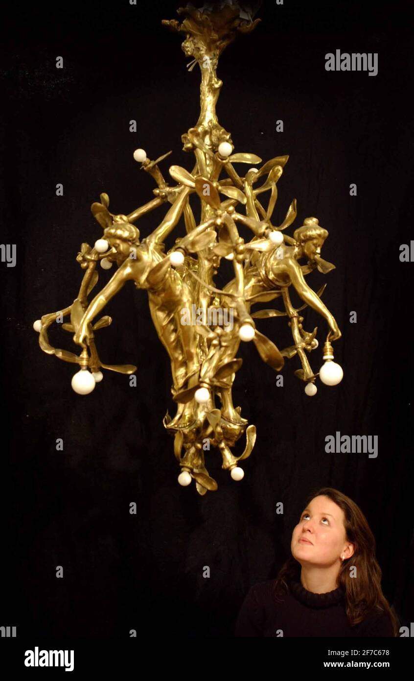 LO STAFF DI SOTHEBYS CON UN LAMPADARIO IN STILE LIBERTY FRANCESE CHE SI PREVEDE SI TERRÀ TRA IL 5 E IL 8,000 A SOTHEBYS DI OLYMPIA VENERDÌ. 9/12/02 PILSTON Foto Stock