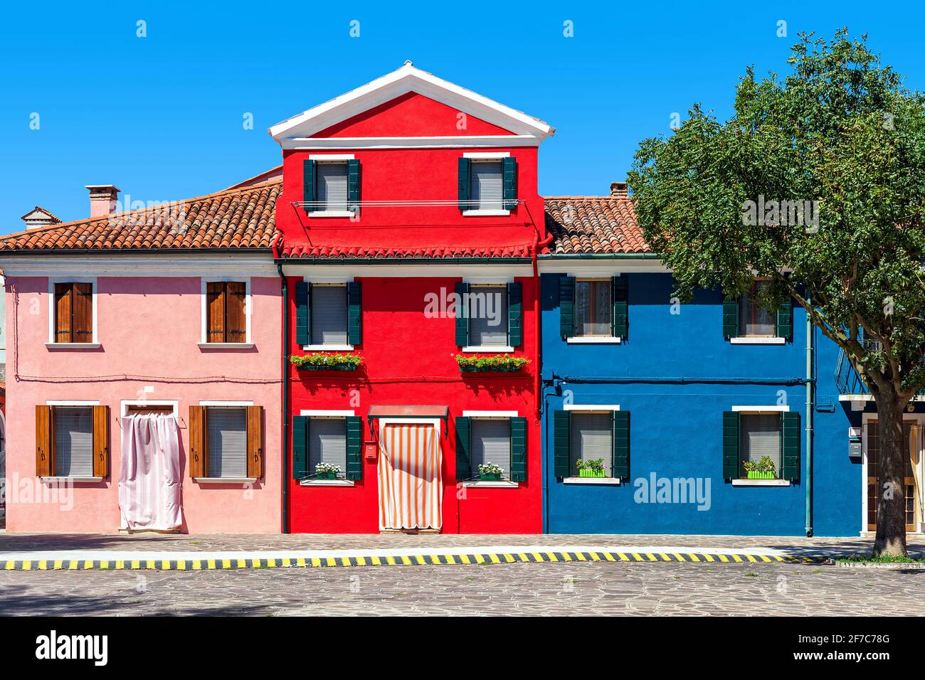 Bella facciata colorata della casa sotto il cielo blu a Burano, Italia. Foto Stock