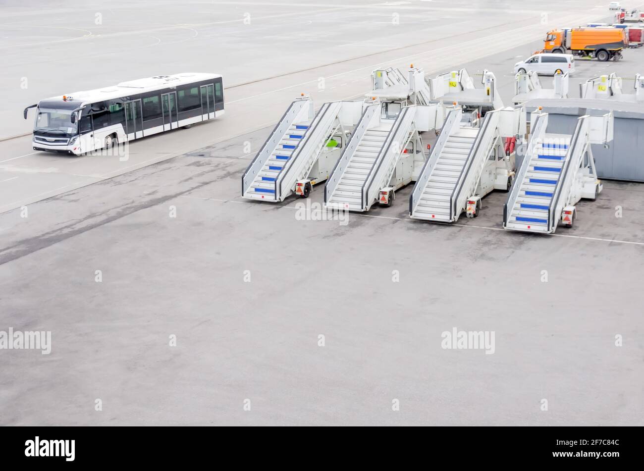 Grembiule aeroportuale con passerelle mobili per aerei e un autobus per il trasporto di passeggeri Foto Stock