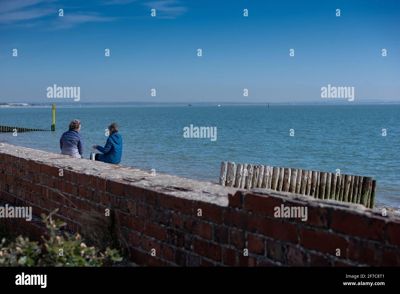 Due OAP che parlano vicino alla spiaggia di fronte al parco di campagna di Lepe tazze di tè Foto Stock