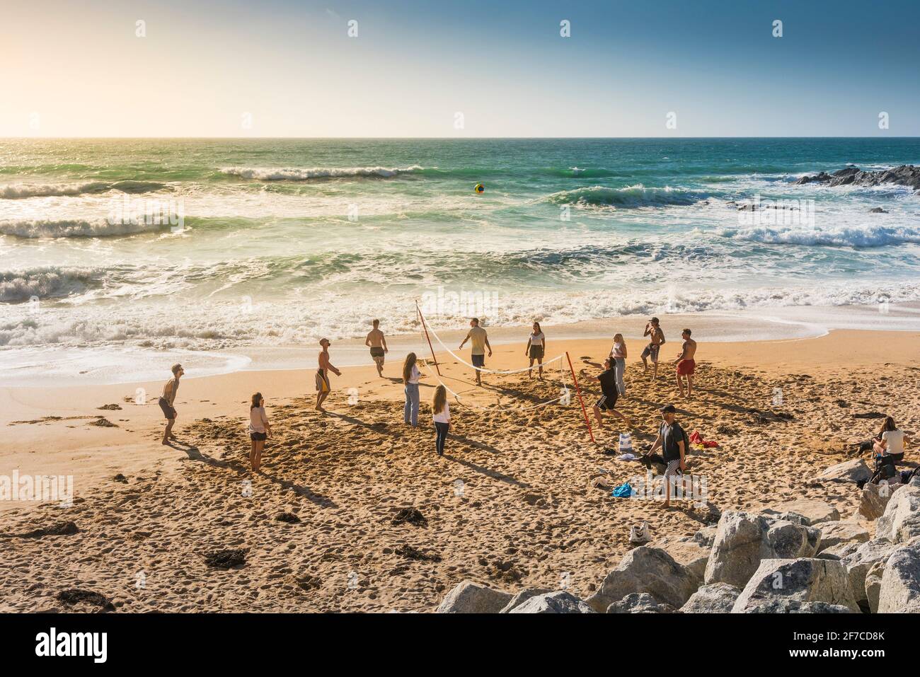 Un gruppo di vacanzieri che gioca una partita di pallavolo sulla spiaggia di Fistral a Newquay in Cornovaglia. Foto Stock