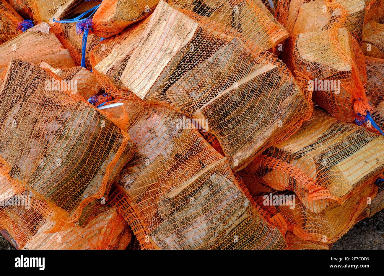 fasci di tronchi di legno tritato avvolti in rete arancione di plastica, norfolk, inghilterra Foto Stock
