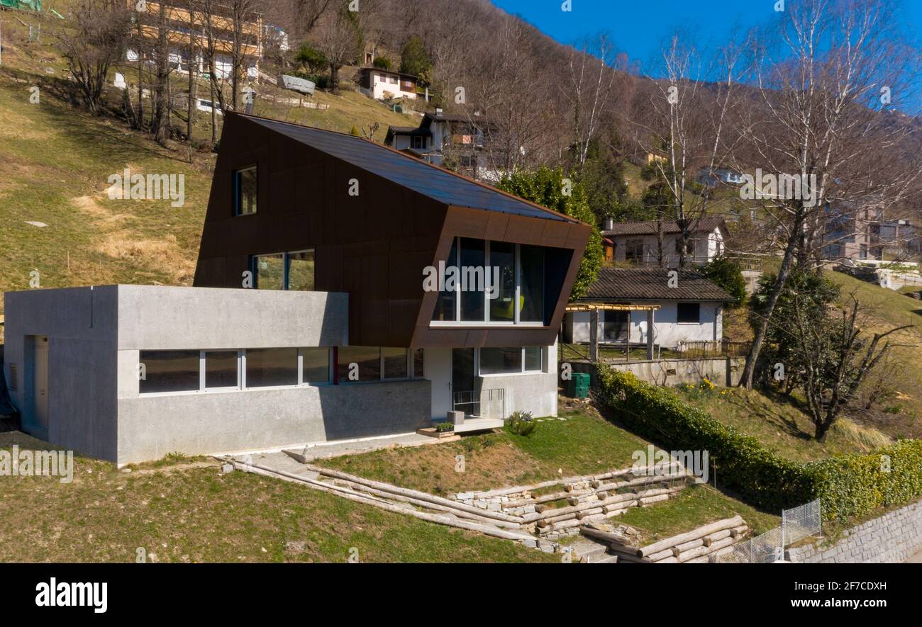 Esterno moderna villa isolata, circondata dalla natura. Rivestimenti in ferro e calcestruzzo. Nessuno dentro. Il posto è nel Canton Ticino, Svizzera. Foto Stock