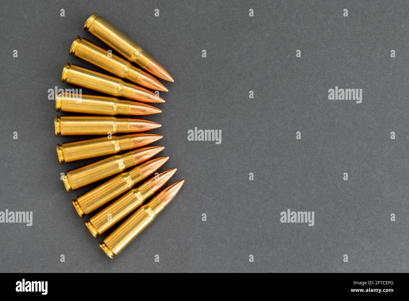 Puntini su sfondo grigio. Cartucce calibro 7.62 per fucile d'assalto Kalashnikov, banner closeup con spazio per la copia. Foto Stock