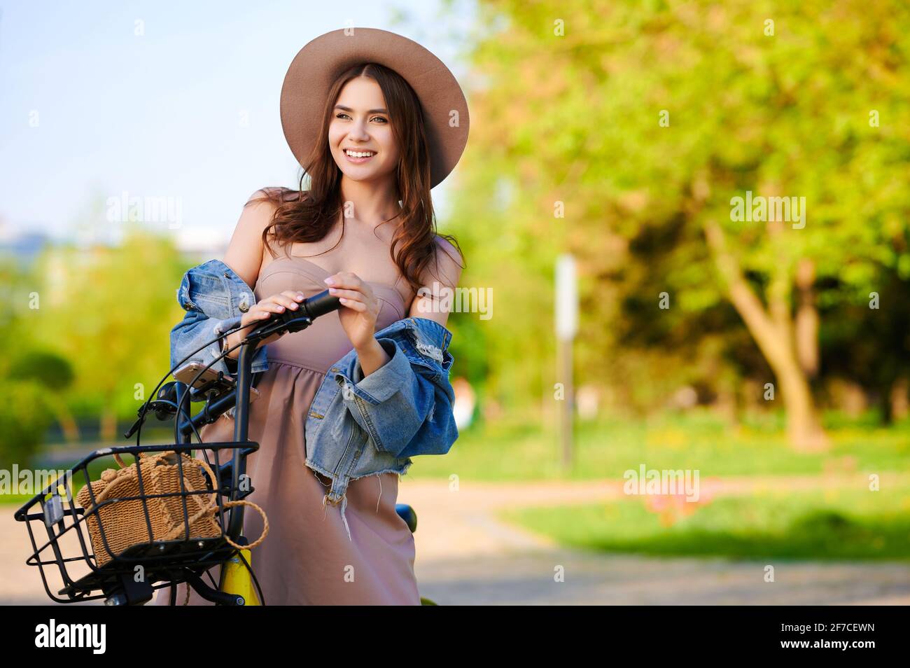 Giovane ragazza sorridente in estate outfit ride noleggio bici in l'estate in città Foto Stock