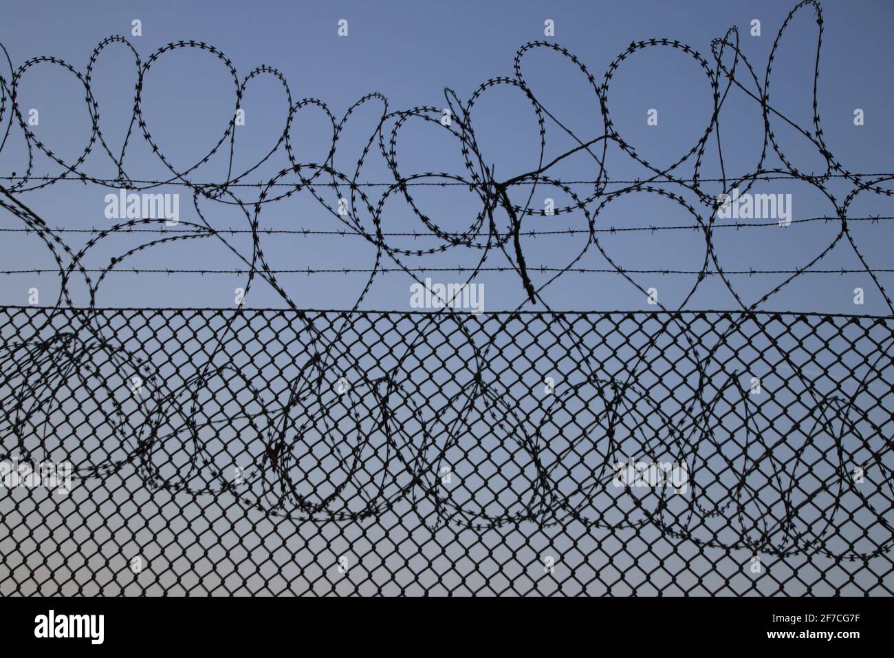 Recinzione di sicurezza dell'aeroporto con cielo blu sullo sfondo Foto Stock