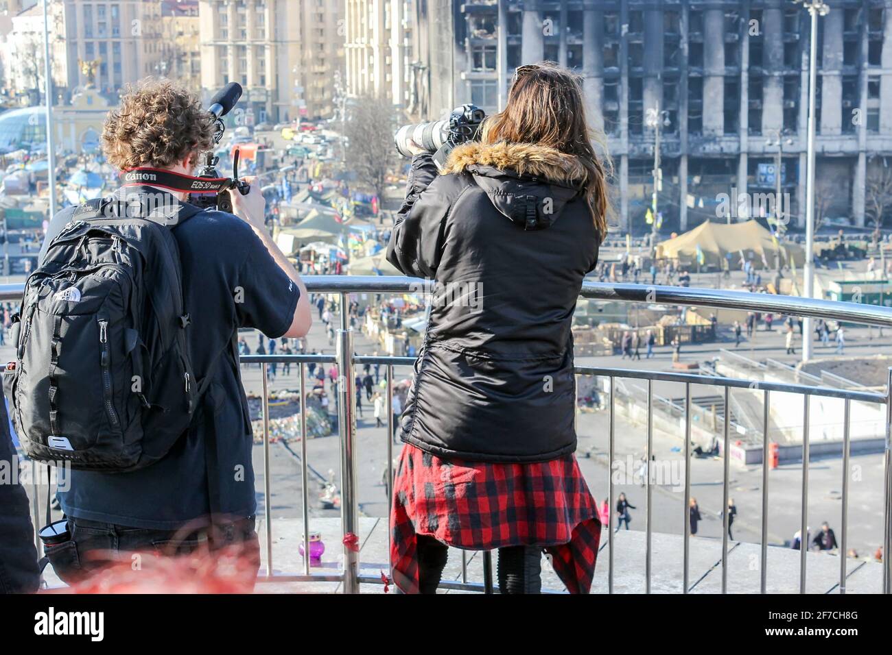 KIEV, UCRAINA - 13 MARZO 2014: Jared Leto e il suo cameraman vicino alla recinzione metallica scattando foto di una città tenda che si erge sopra il Maidan Nezalezhnosti Foto Stock