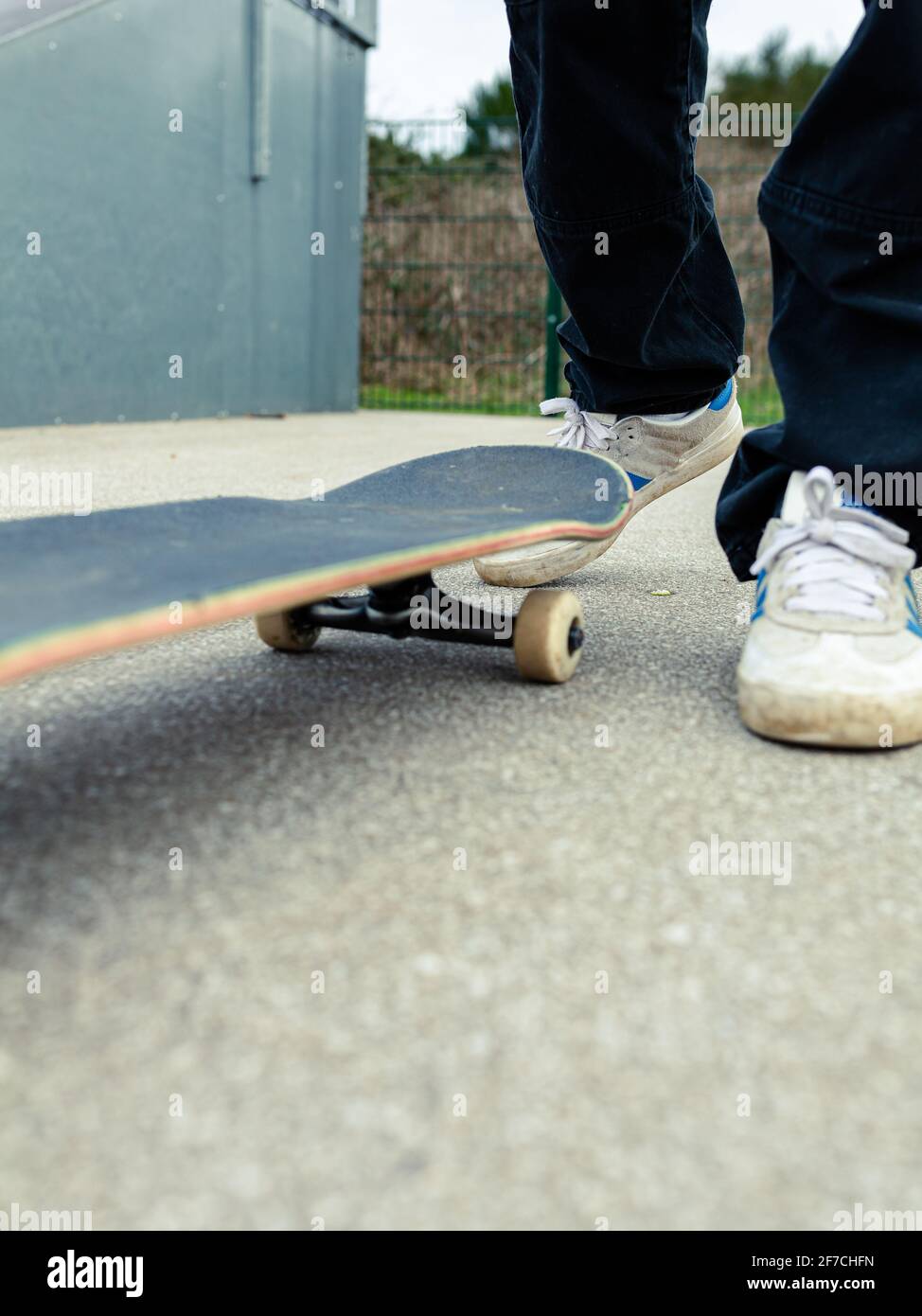Primo piano di uno skateboard con una persona sconosciuta in piedi dietro di esso. Skateboard concetto di stile di vita sano Foto Stock