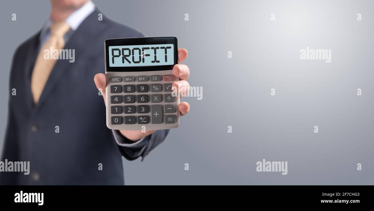 Businessman mostra calcolatrice con il testo profitto. Calcolatrice visualizza la parola PROFITTO. Concetto di offerta redditizia da una banca. Prestito, ipoteca, deposito, Foto Stock