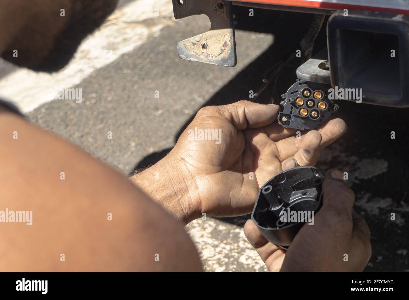 Uomo che ripara il dispositivo elettrico di un'automobile Foto Stock