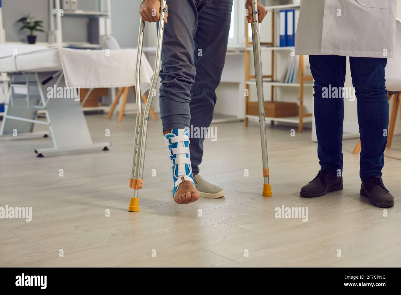 Sezione centrale del paziente con gambe ferite e grondoli sotto controllo medico Foto Stock