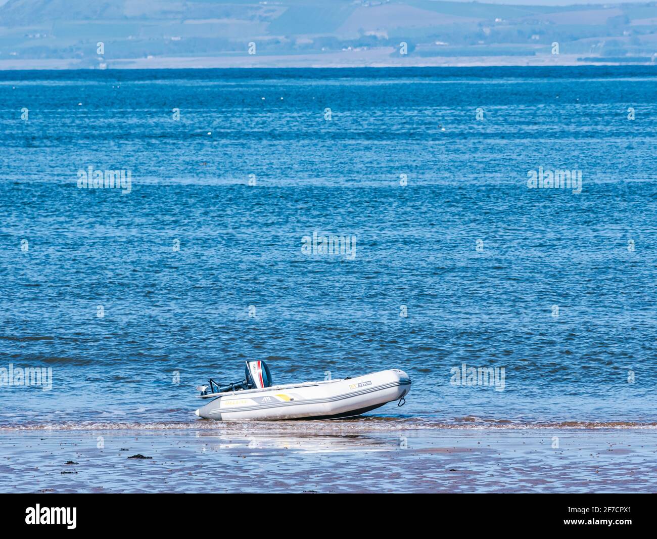 Piccolo gommone gonfiabile in gomma con motore fuoribordo in acqua sulla  costa in giornata di sole, Firth of Forth, Scozia, Regno Unito Foto stock -  Alamy