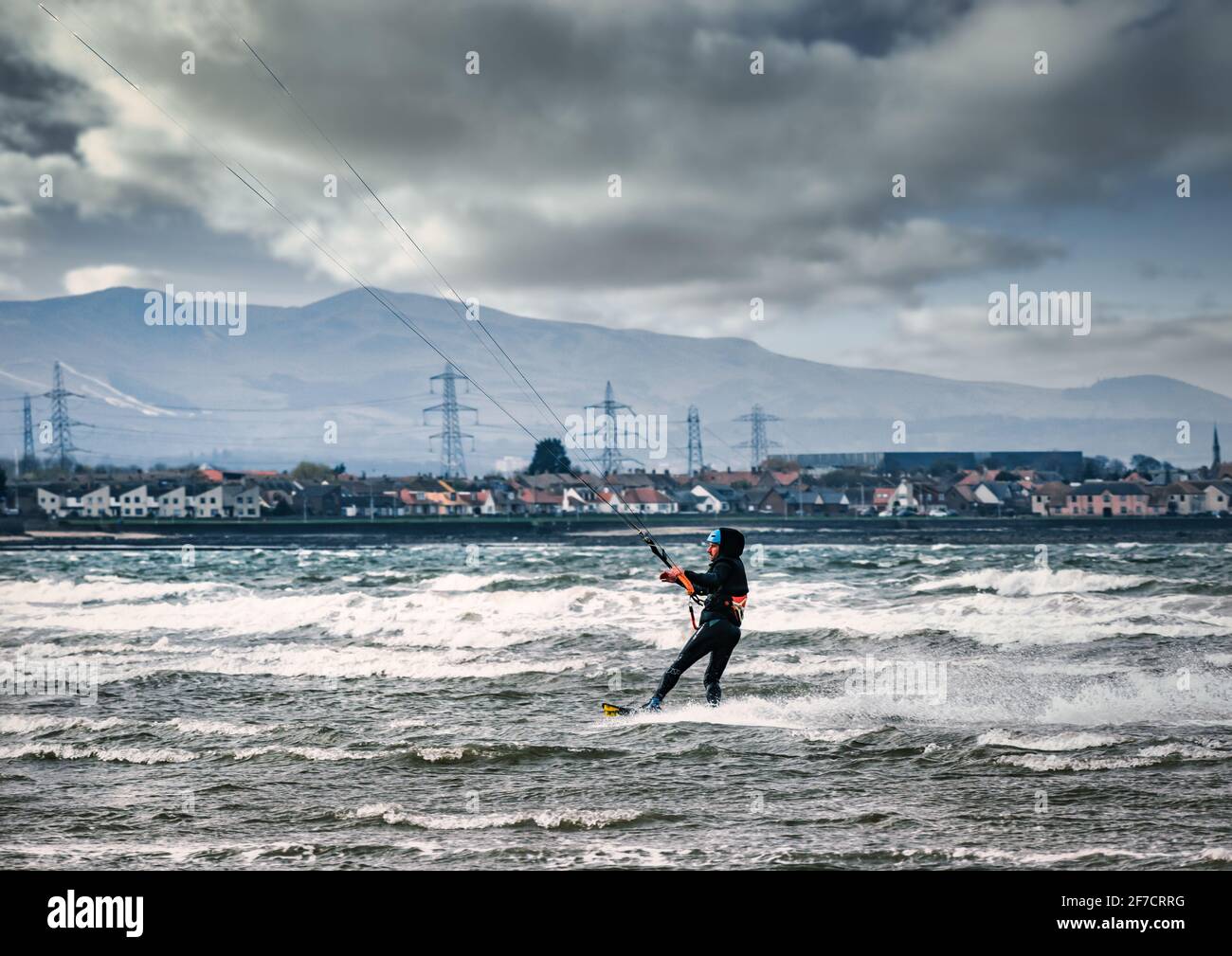 Man kite surf a Longniddry Bents in giornata ventosa in mare agitato, Firth of Forth, Scozia, Regno Unito Foto Stock