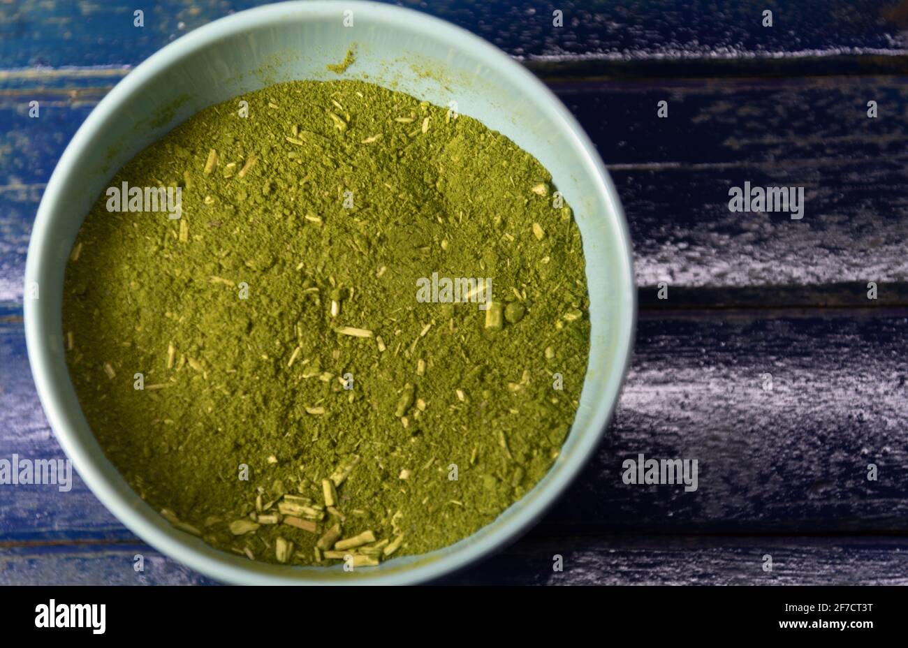 Canister con yerba mate su sfondo blu. Yerba mate è una pianta medicinale che ha un sottile stelo grigio, foglie ovali e piccoli frutti di un verde o pur Foto Stock