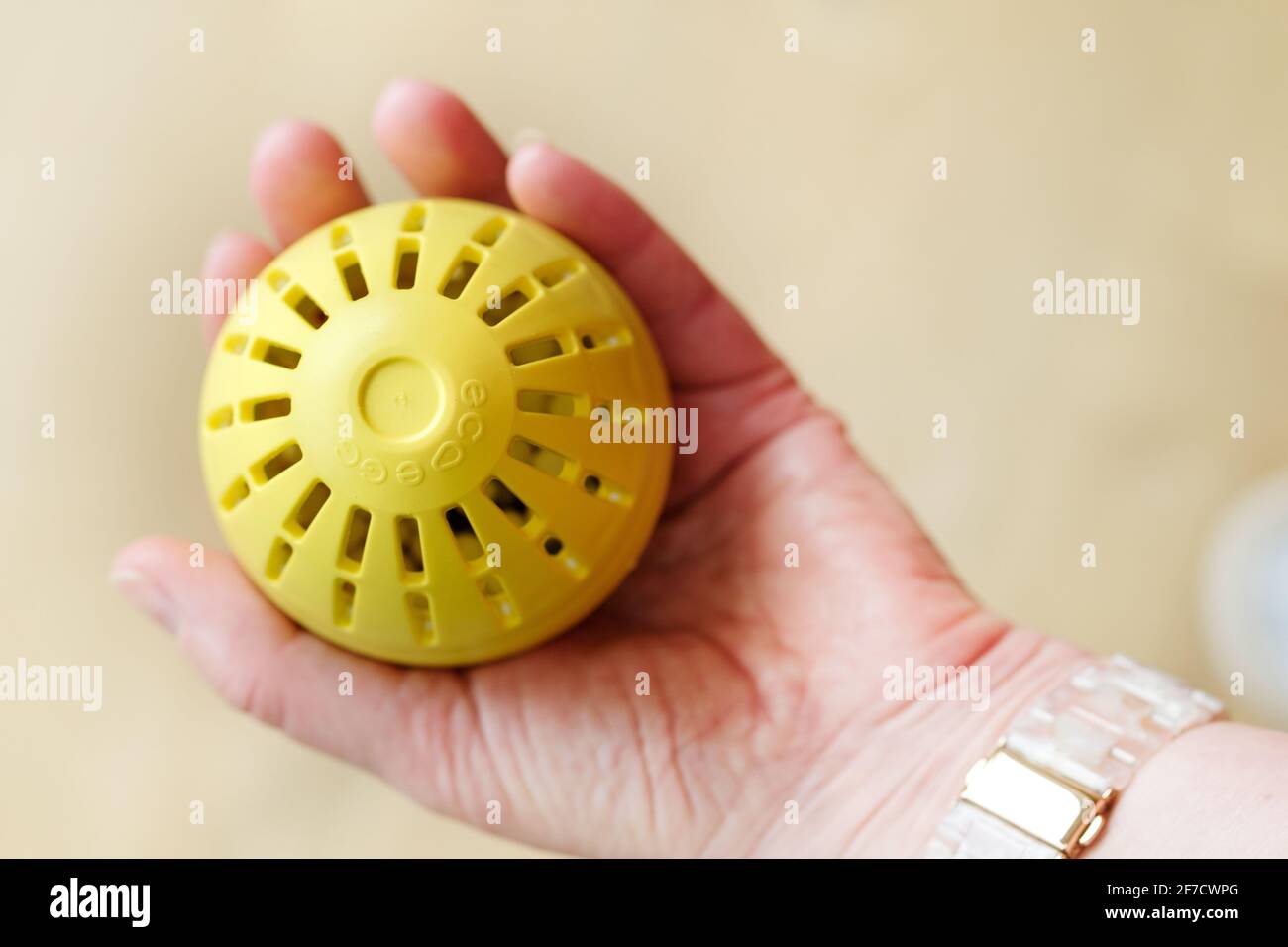 Una donna che tiene un uovo di bucato di ecouovo in mano. L'ecouovo è un sostituto detergente ecologico per il lavaggio dei tessuti Foto Stock