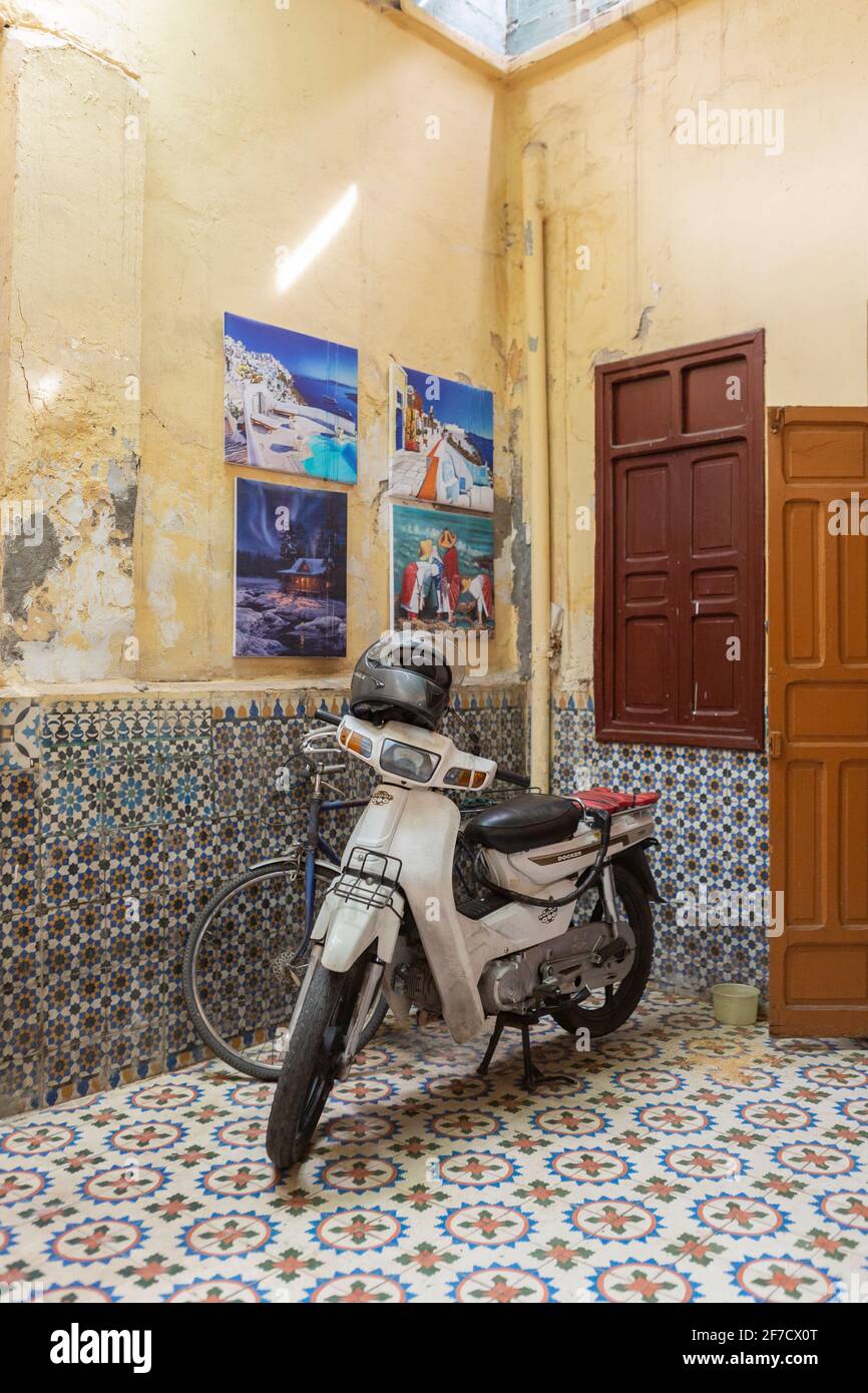 Tipico scooter in un cortile splendidamente piastrellato a Marrakech, Marocco Foto Stock