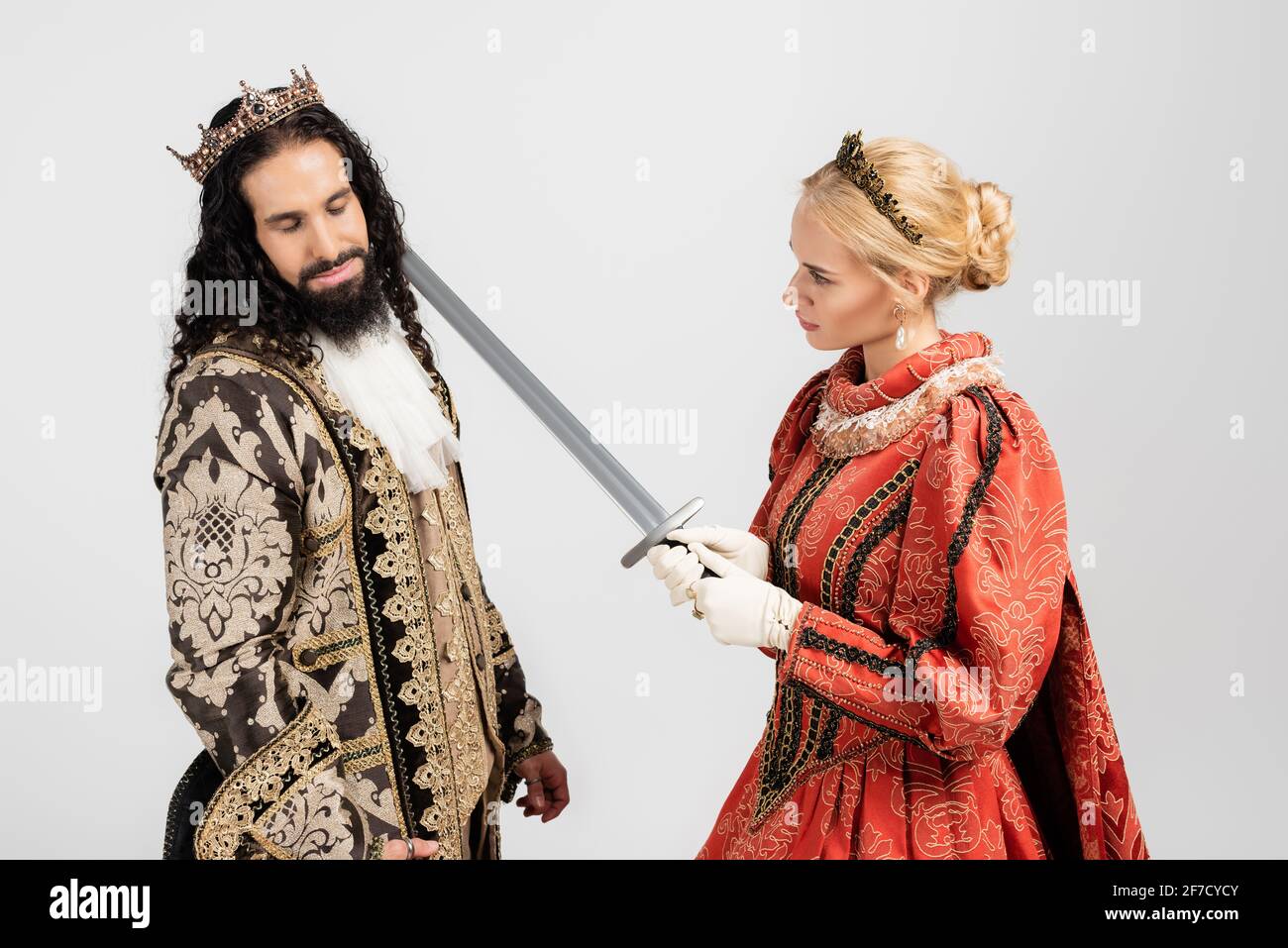 regina bionda che tiene la spada vicino al collo del re ispanico dentro  abbigliamento medievale isolato su bianco Foto stock - Alamy