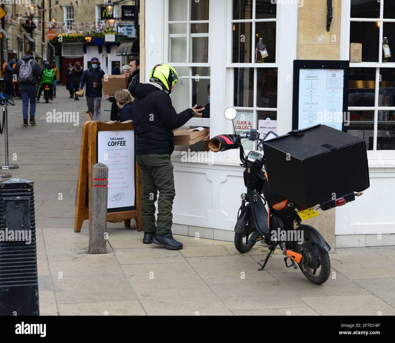 cambridge, Regno Unito, Inghilterra, 03-04-2021. Il ciclista raccoglie il cibo dall'area designata presso il ristorante pizzeria. Foto Stock