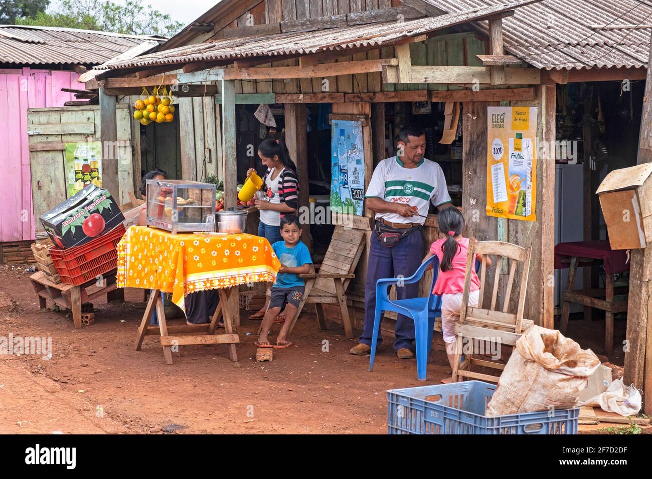 Famiglia Paraguayana che vende cibo e bevande da un negozio di legno primitivo nella città di Edelira, nella rurale Itapúa, Paraguay Foto Stock