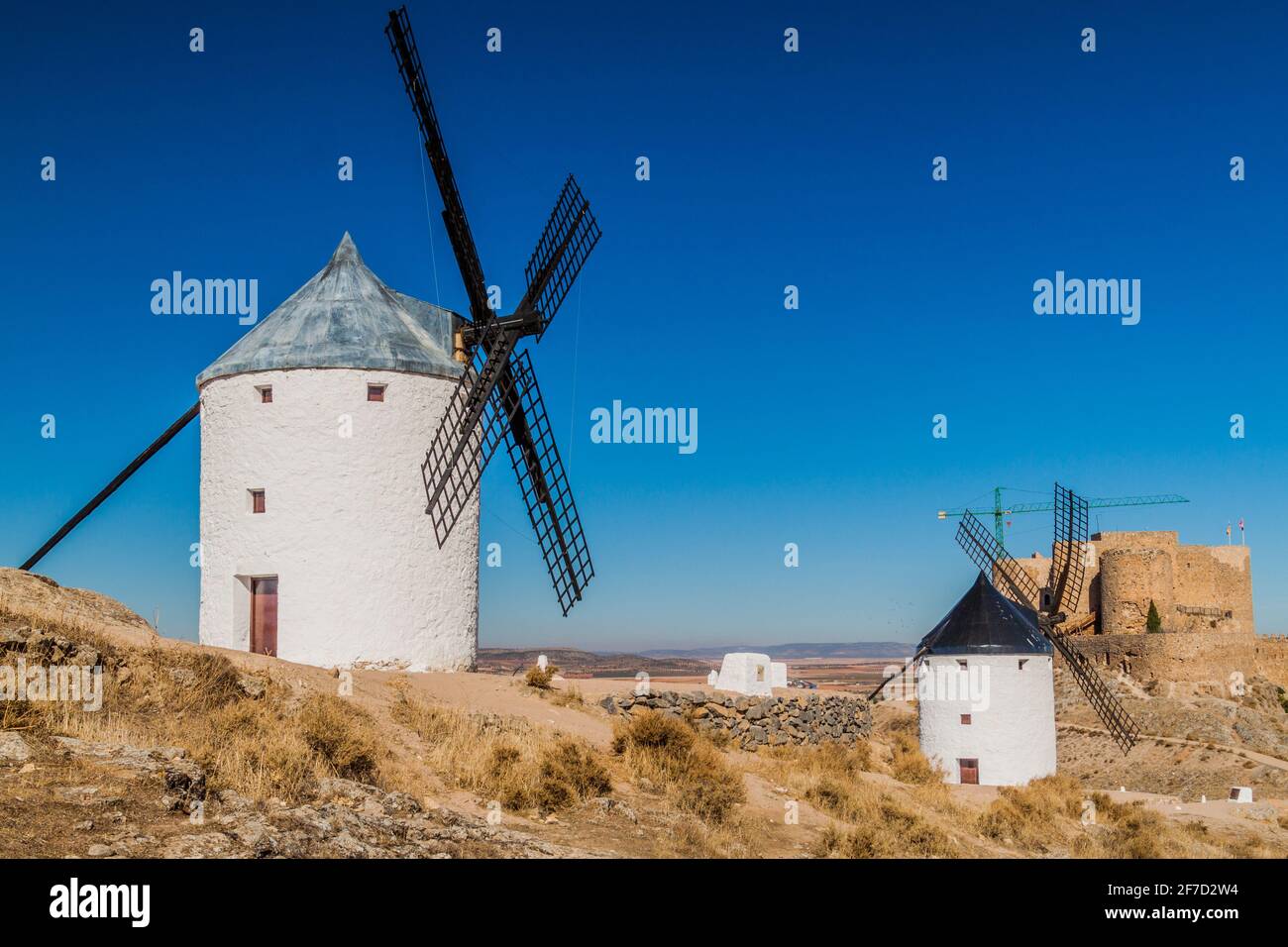 Mulini a vento e un castello nel villaggio di Consuegra, Spagna Foto Stock