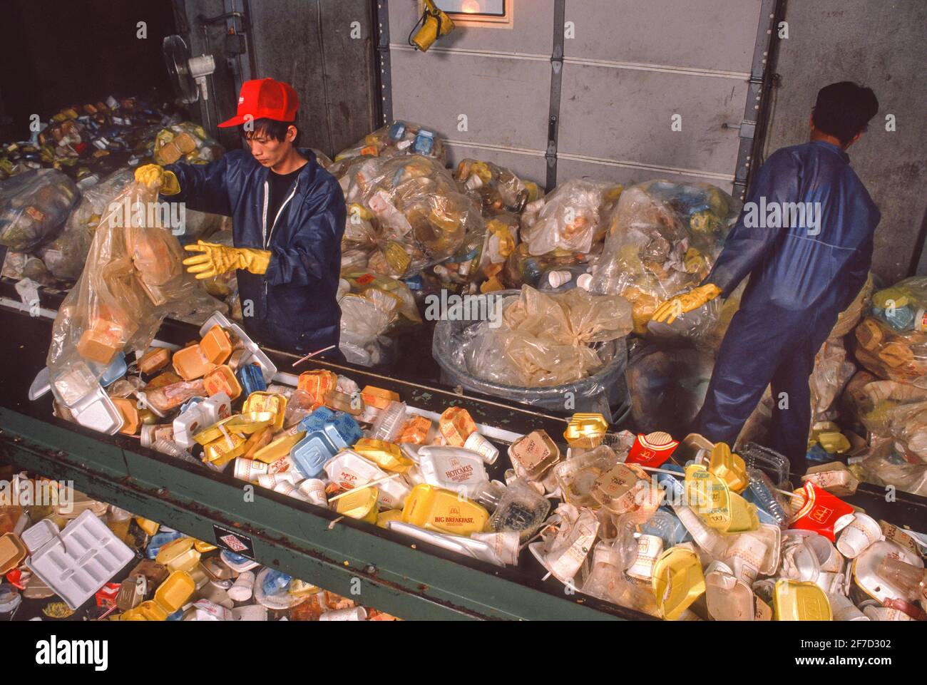 LEOMINSTER, MASSACHUSETTS, USA, 7 AGOSTO 1990 - due uomini al lavoro che riciclano contenitori di fast food in polistirene, styrofoam, a Plastic Again Plant. Foto Stock