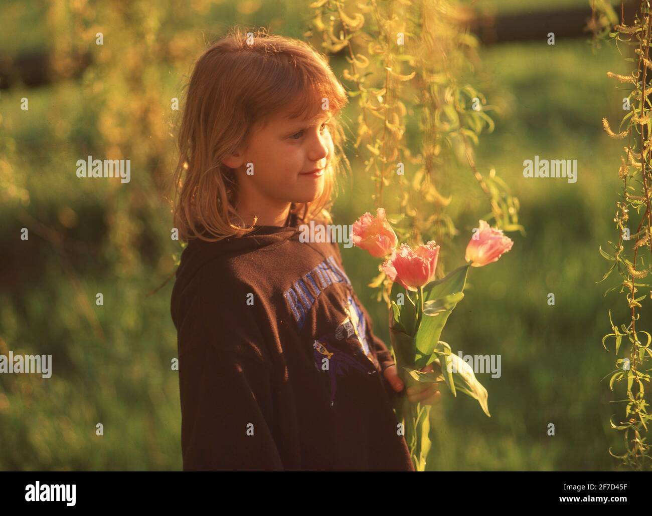 Giovane ragazza che raccoglie fiori selvatici in giardino, Winkfield, Berkshire, Inghilterra, Regno Unito Foto Stock