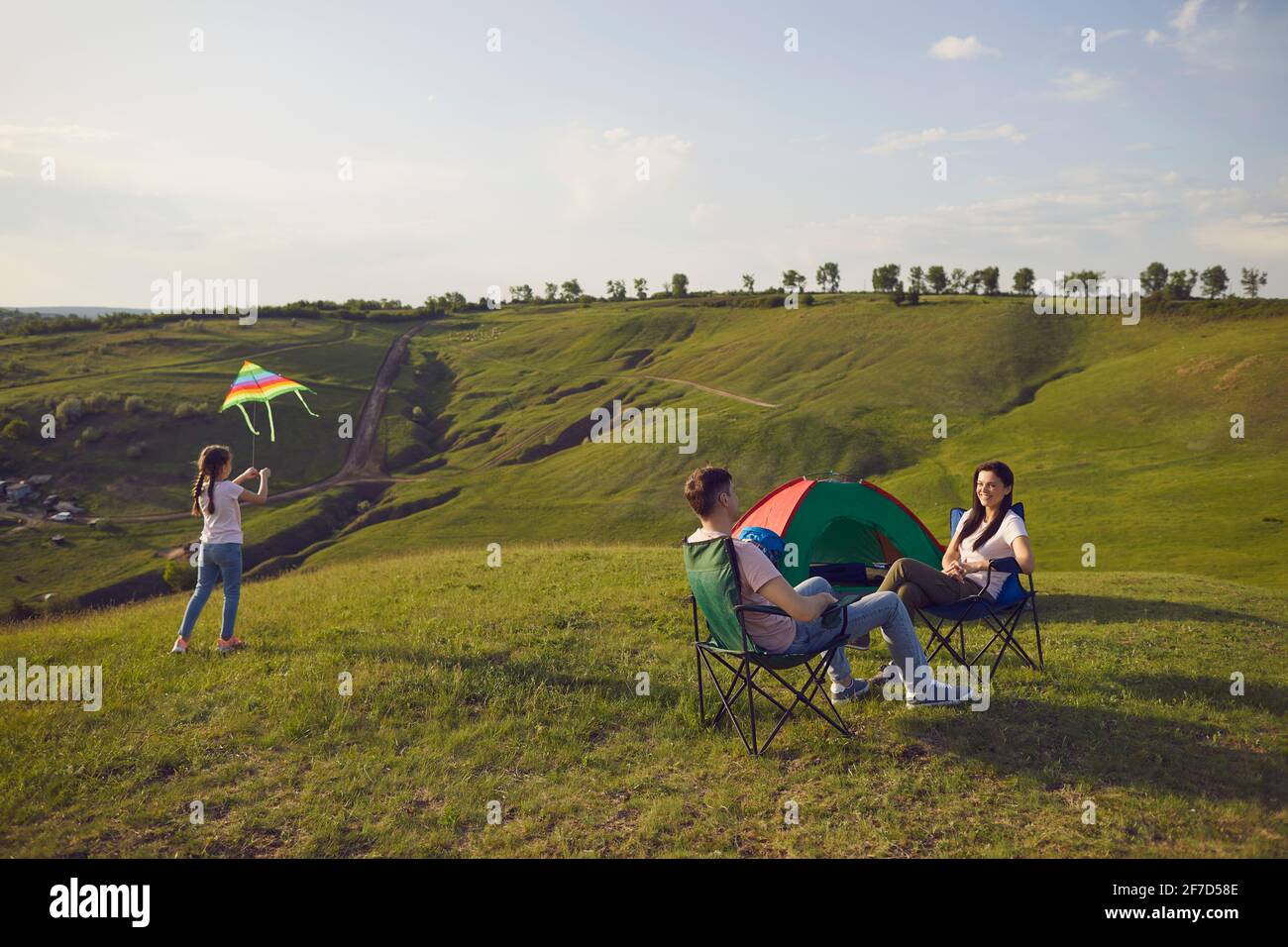 Famiglia in viaggio che riposa in campo nella natura estiva Foto Stock
