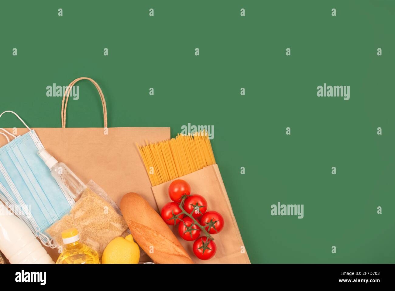 Composizione con donazioni di cibo e medicinali e sacchetto di carta su sfondo verde con spazio per la copia: Pasta, verdure, cibo in scatola, baguette, cucina Foto Stock