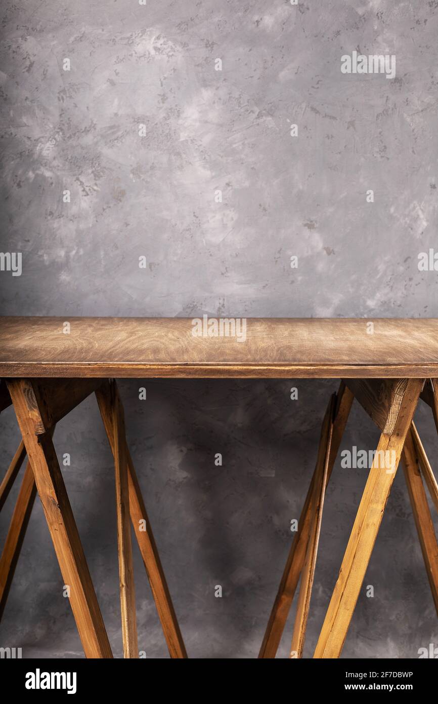 tavolo o piano di lavoro in legno vicino allo sfondo della parete in cemento, posto per le attrezzature Foto Stock