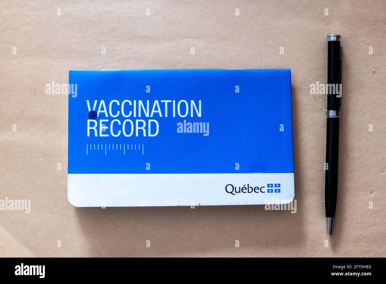 Toronto, Ontario, Canada - 1 febbraio 2021: Pamphlet record di vaccinazione del Quebec e pen flat tortuoso posato su pergamena. Foto Stock