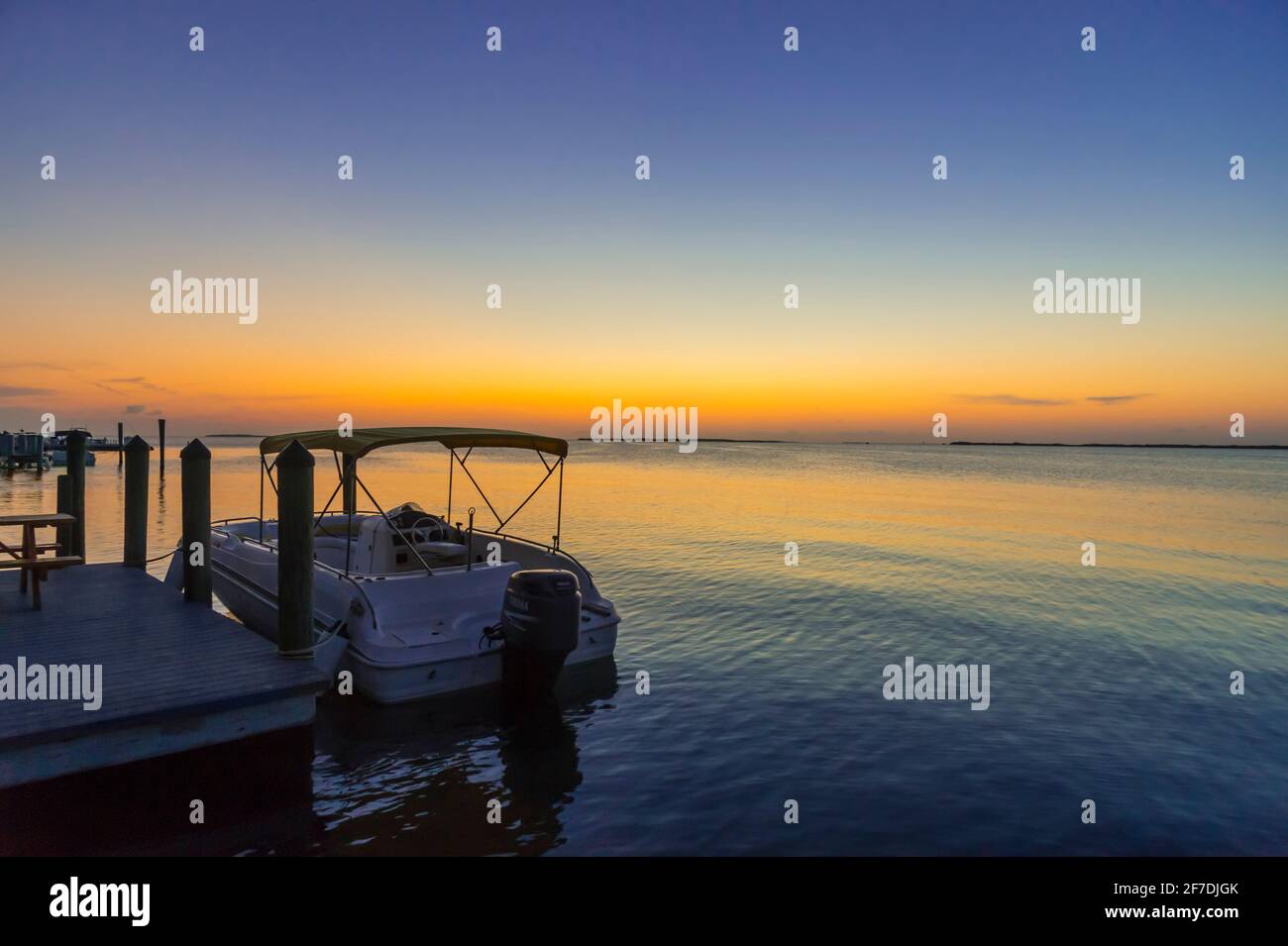Barca solitaria alla fine del molo al tramonto, Key Largo Florida USA Foto Stock