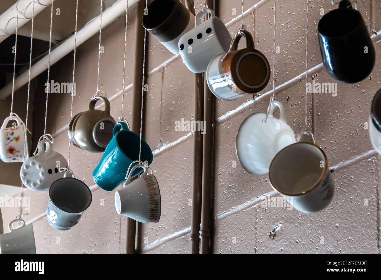 Tazze di ceramica da tè o caffè che penzolano dalle corde in un carino caffè retrò in inverno. Foto Stock