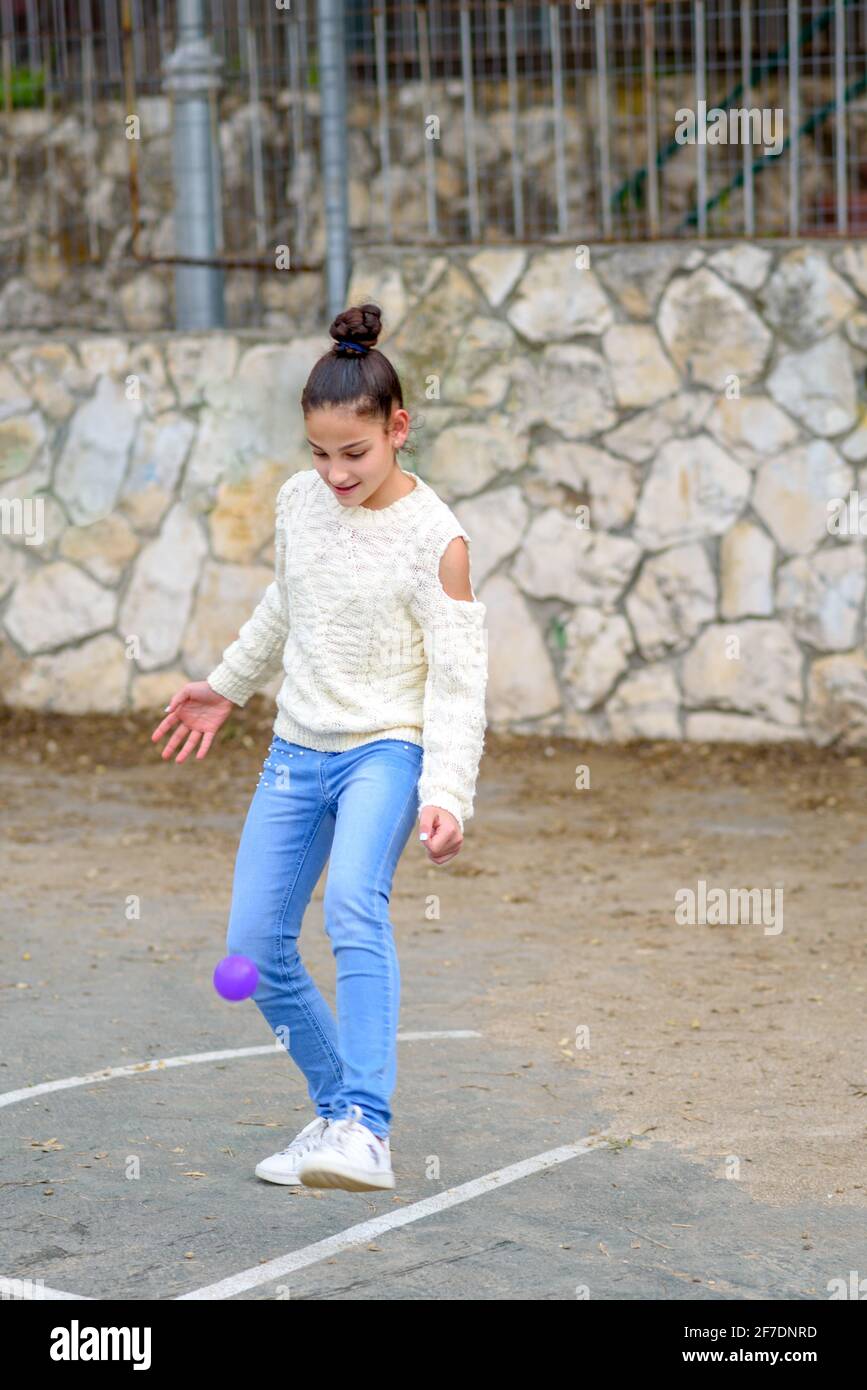 Adolescente bella ragazza slim giocatore di calcio allenamento con palla piccola su campo sportivo. Foto Stock