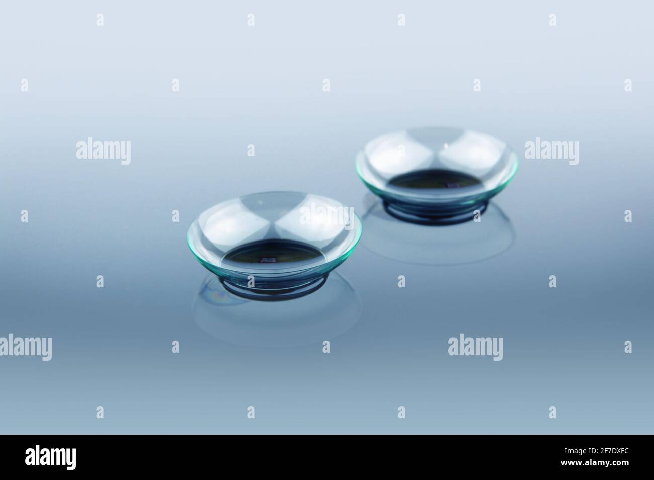 Due lenti a contatto con riflessi su sfondo blu Foto Stock