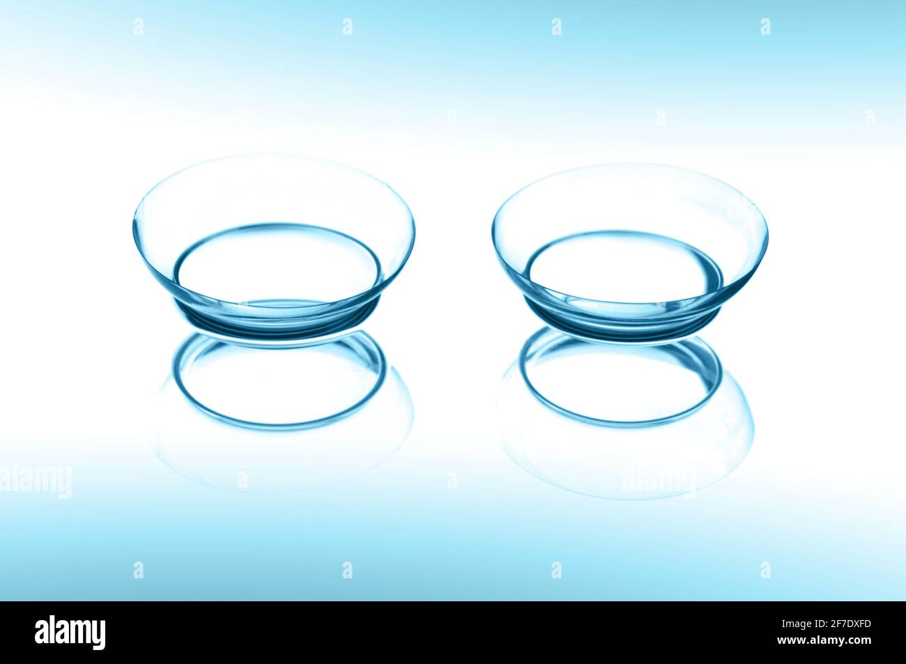 Due lenti a contatto con riflessi su sfondo blu Foto Stock