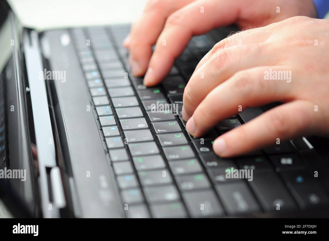 Mani maschio digitando su una tastiera portatile Foto Stock