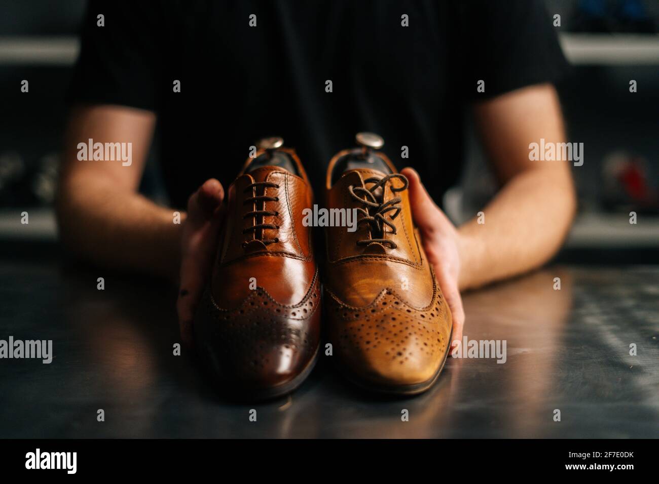 Mani ravvicinato del calzolaio maschile tiene la vecchia scarpa in pelle  marrone chiaro e riparata scarpe lucide dopo il lavoro di restauro Foto  stock - Alamy