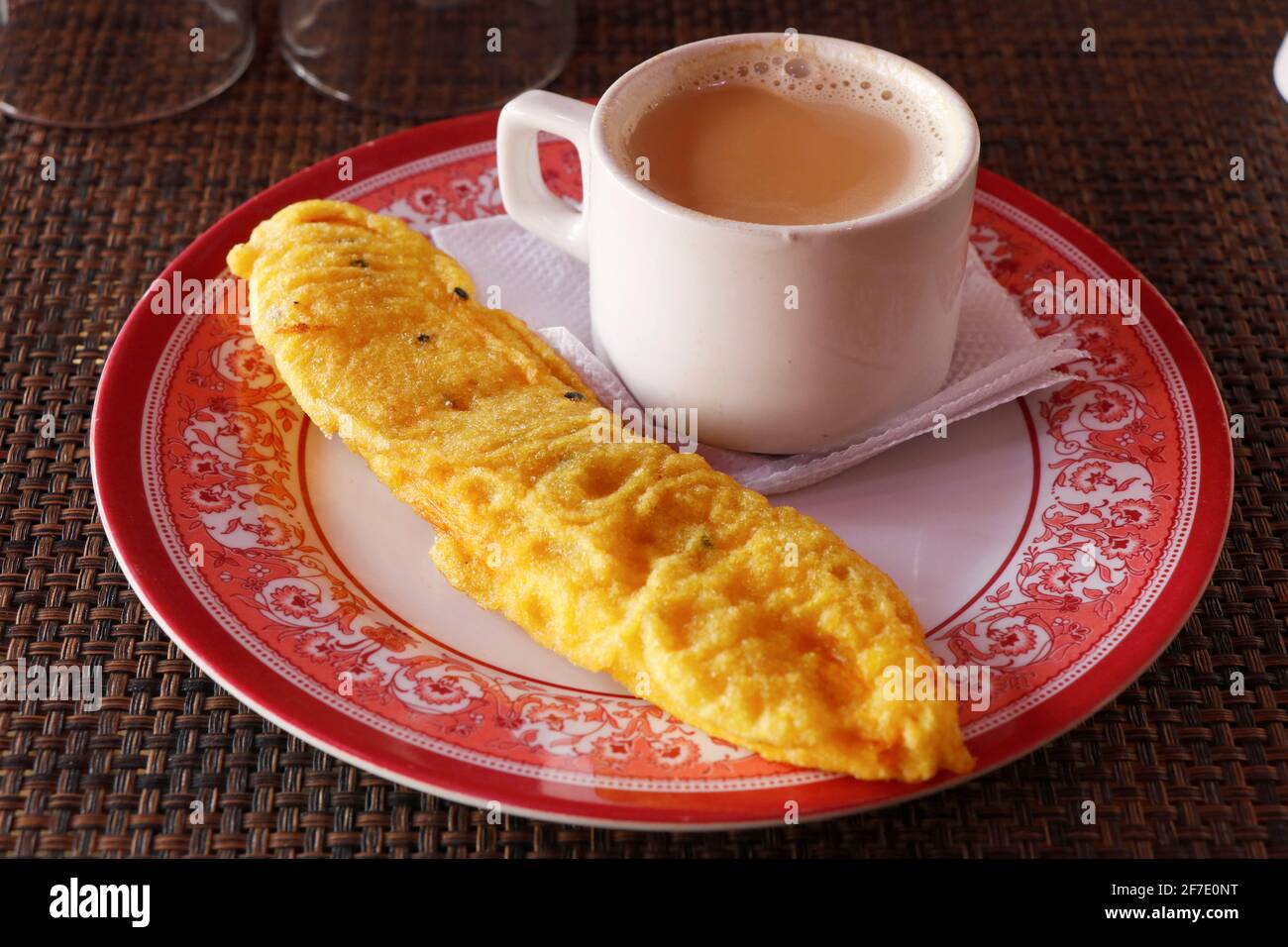 cibo di strada indiano, tè con frittelle di banana in un piatto Foto Stock