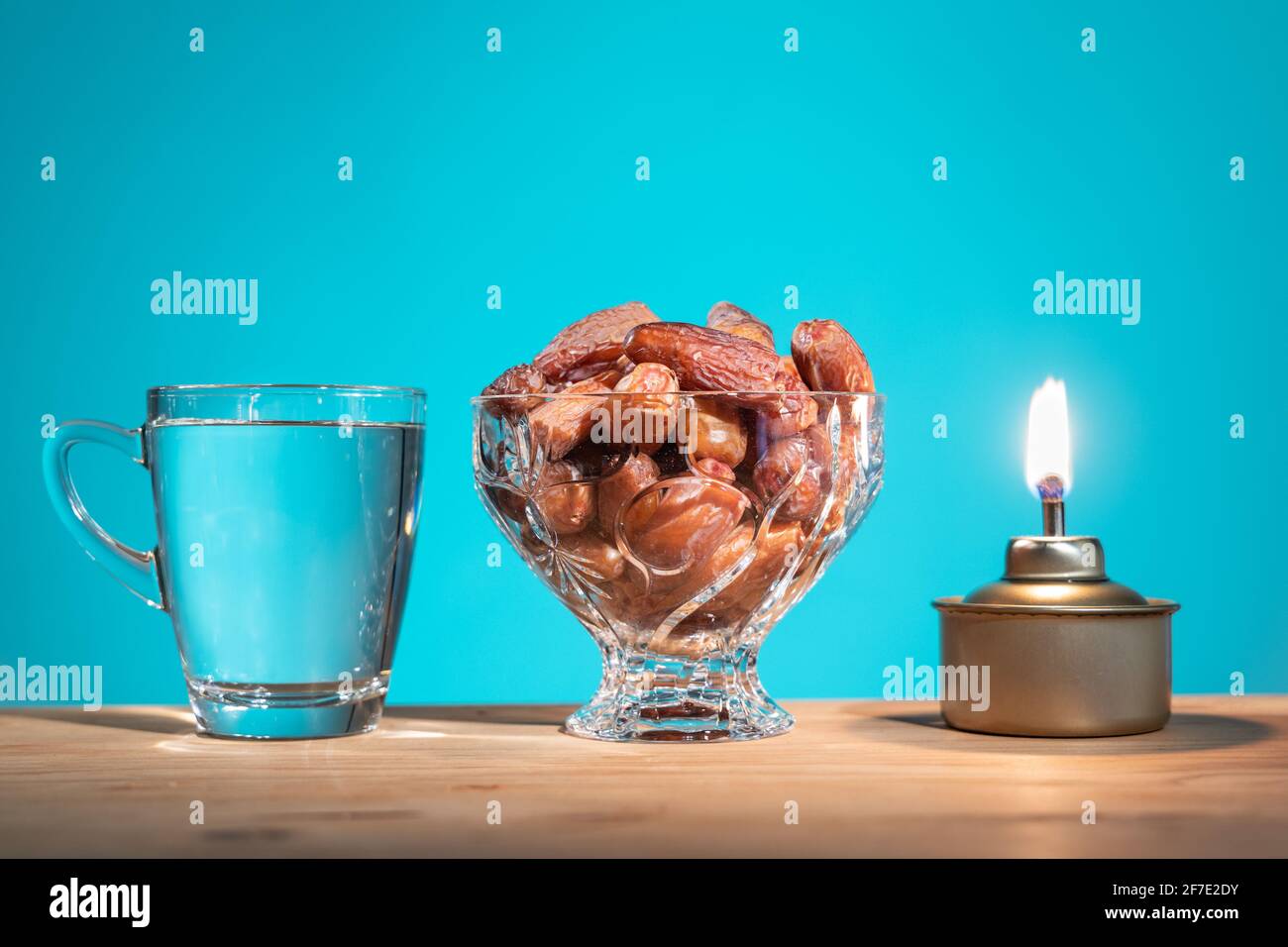 Iftar musulmano di rottura del fast food durante il mese di Ramadan con datteri dolci conservati e acqua. Lampada olio PELITA come prop. Foto Stock