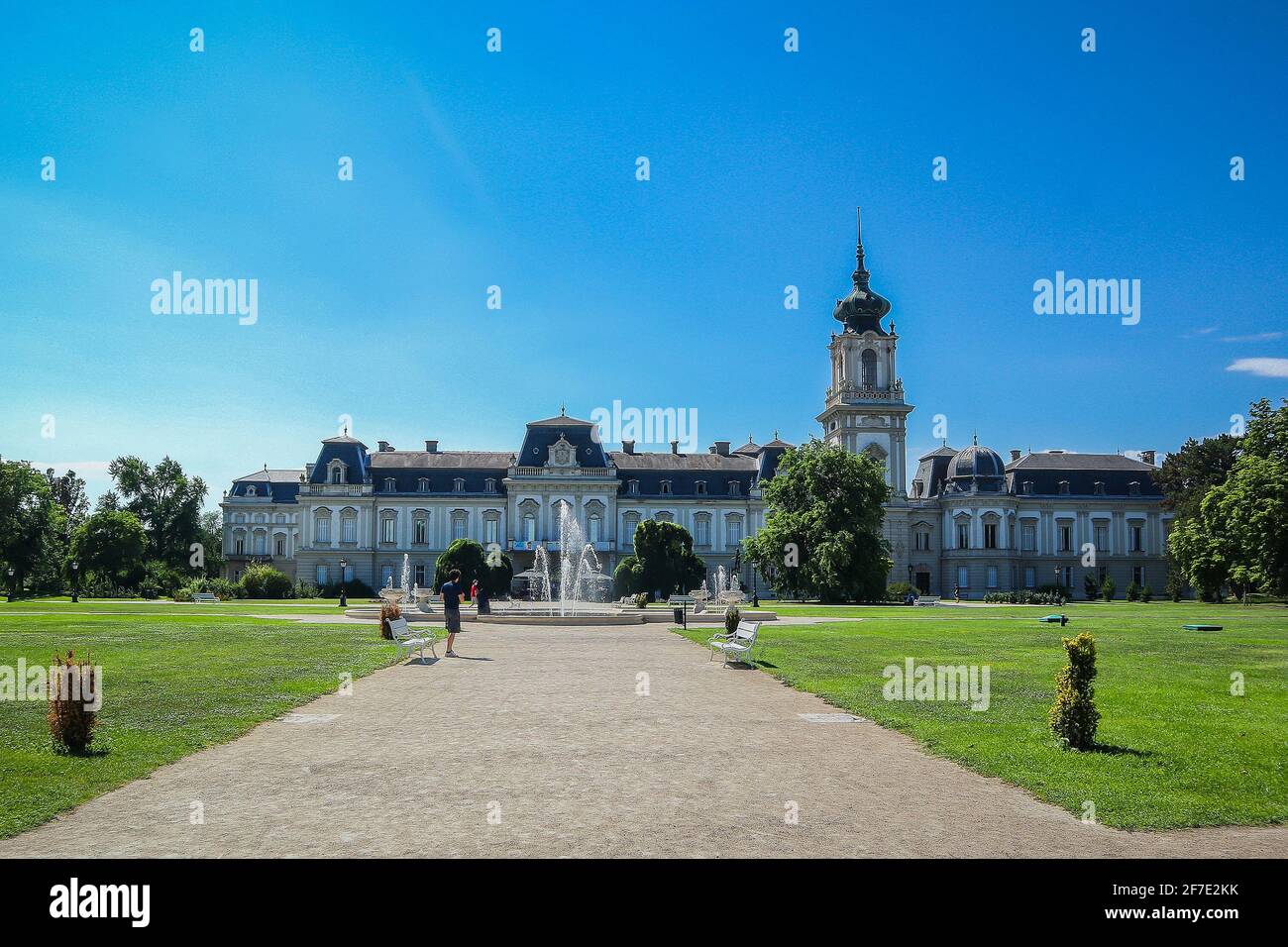 Festetics Palace dietro splendidi giardini a Keszthely, Ungheria, in una giornata di sole limpido. Vista del palazzo e dei giardini, e alcuni turisti. Foto Stock