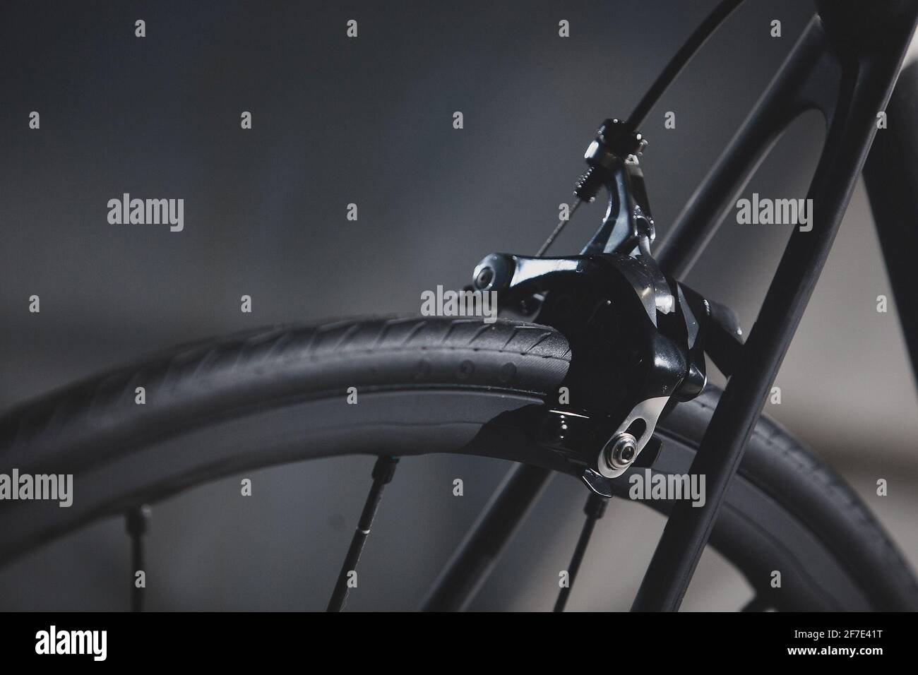 Particolare del freno posteriore e del telaio di una bicicletta da strada su fondo nero setoso. Foto Stock