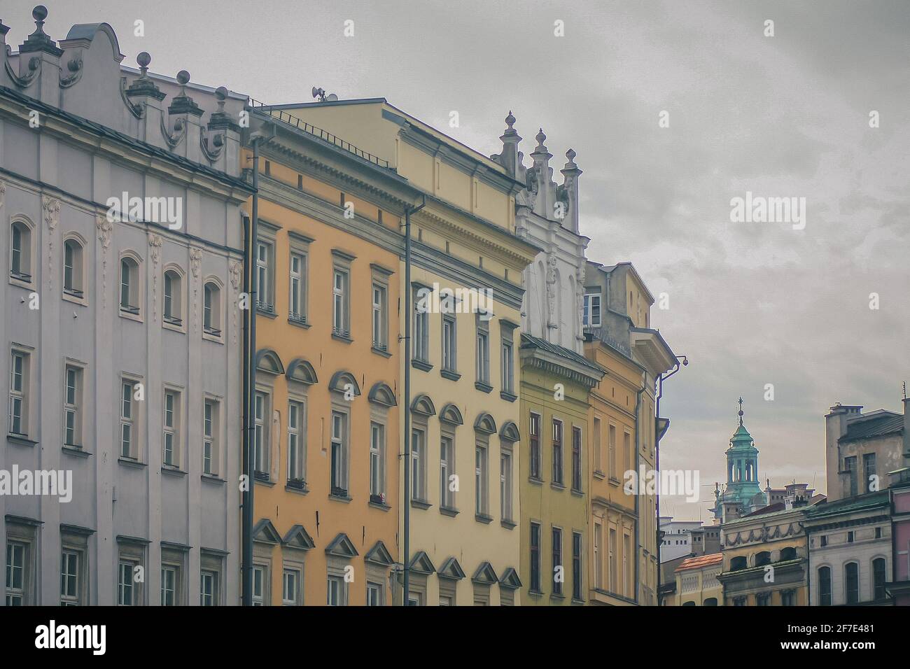 Una fila di case a Cracovia, Polonia. Case tipiche nel centro della città di Cracovia, facciate colorate in fila che si trasformano in una curva su un grigio Foto Stock