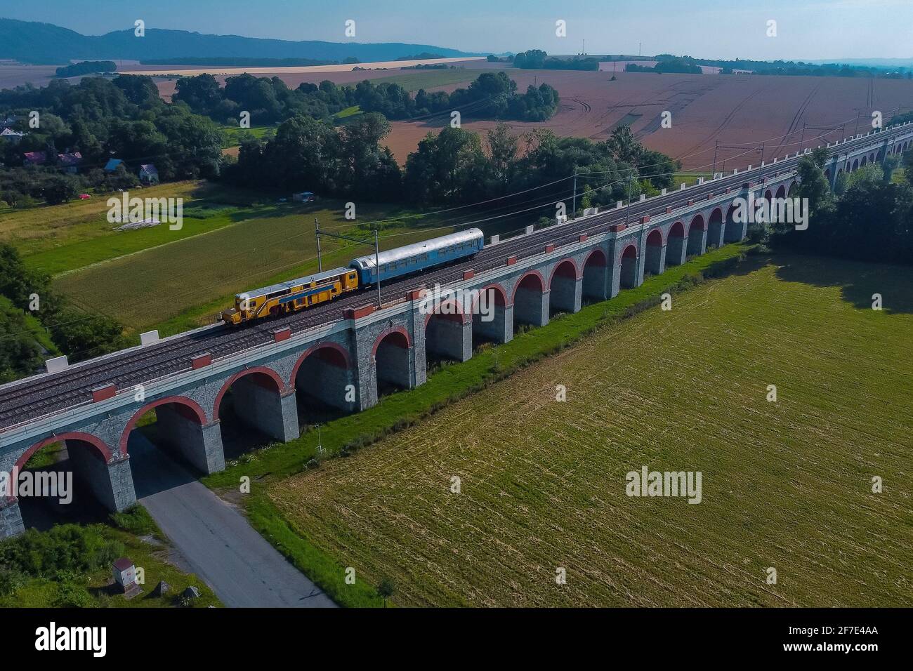 Vista del viadukty jezernicke o Viadotto a Jezernice nella repubblica Ceca, viadotto ad arco sulla valle in tempo soleggiato con un treno di lavoro che la guida sopra. Foto Stock