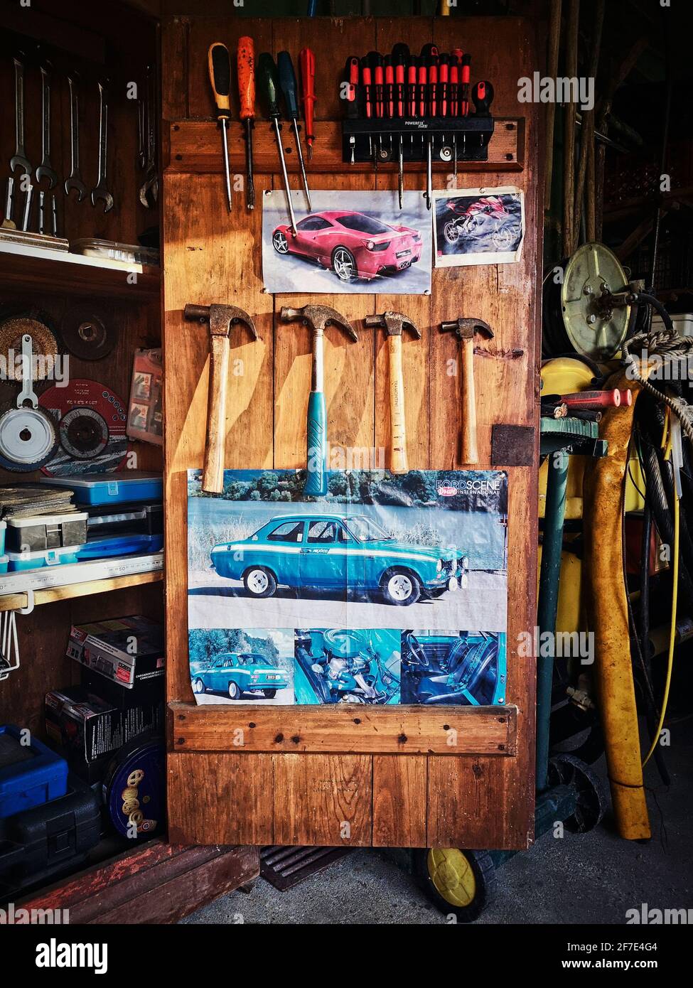 Attrezzatura da lavoro all'interno di un armadio con poster per auto. Aprire un armadio in legno con utensili da lavoro Foto Stock