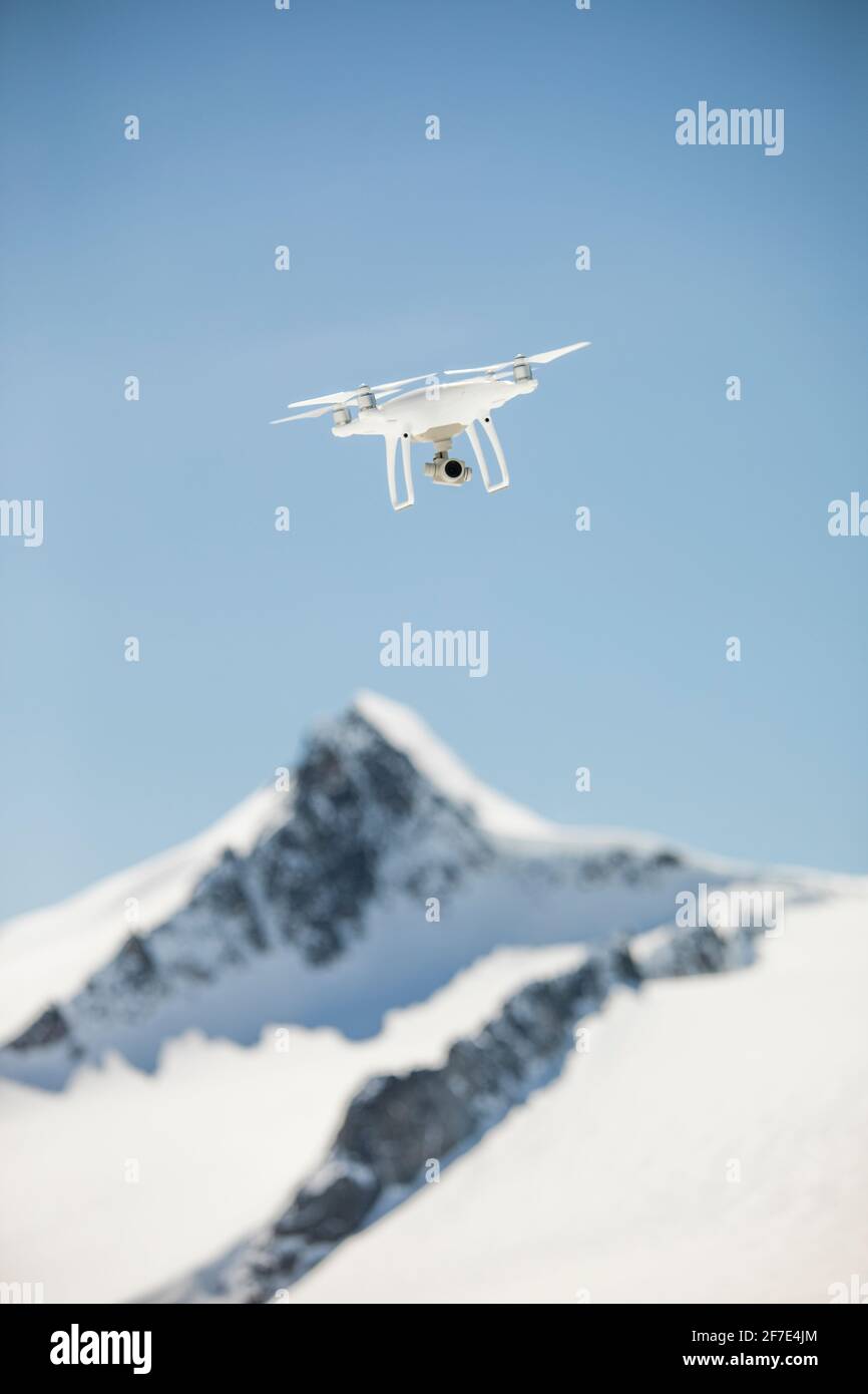Il drone vola a mezz'aria sopra una cima di montagna, British Columbia. Foto Stock