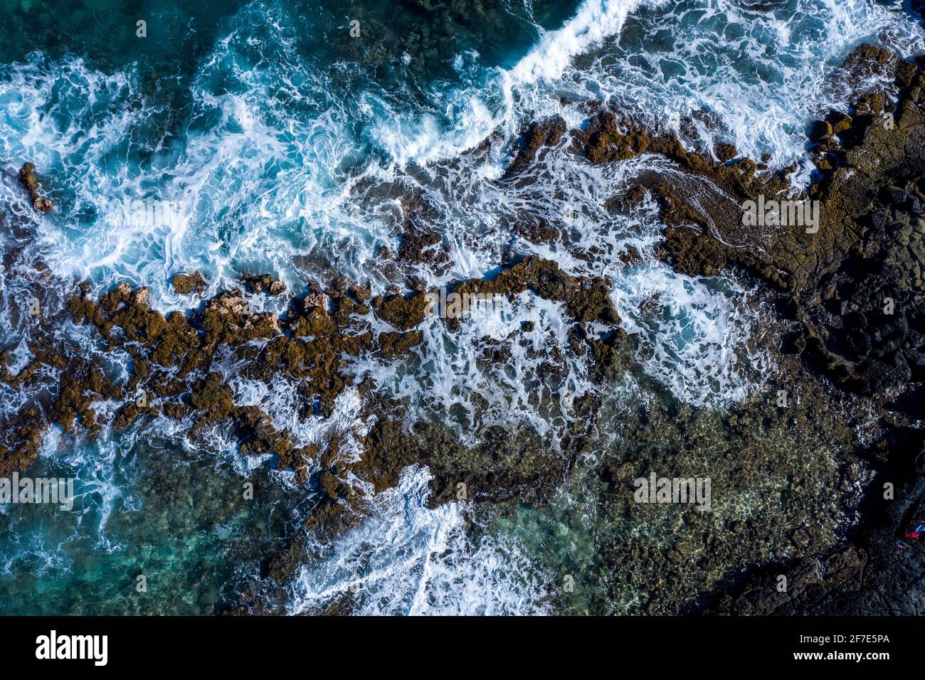 Drone foto di potenti onde che abbracciano una superficie rocciosa dentro Hawaii Foto Stock