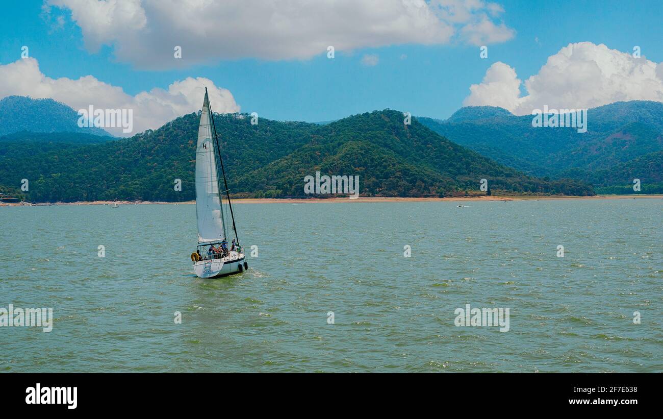 Messico, Valle de Bravo 26 marzo 2021, una barca a vela che si affaccia sulle acque del lago una bella composizione con lo sfondo Foto Stock