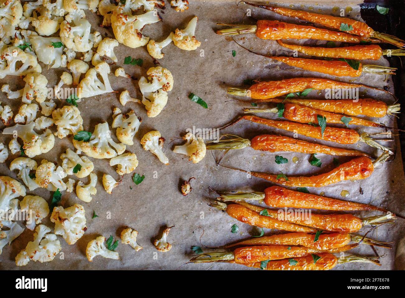 primo piano di carote arrostite e cavolfiore su carta pergamena Foto Stock