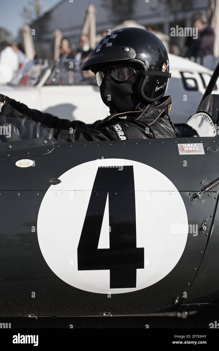 Pilota da corsa con maschera facciale, occhiali e casco al Goodwood Revival, West Sussex, England.Man indossando occhiali da corsa e casco di sicurezza. Foto Stock