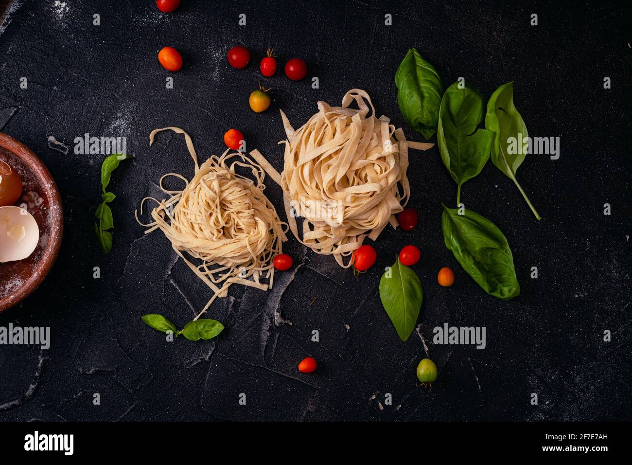 plano cenital platone con fideos caseros sobres base negra ajo oliva Foto Stock